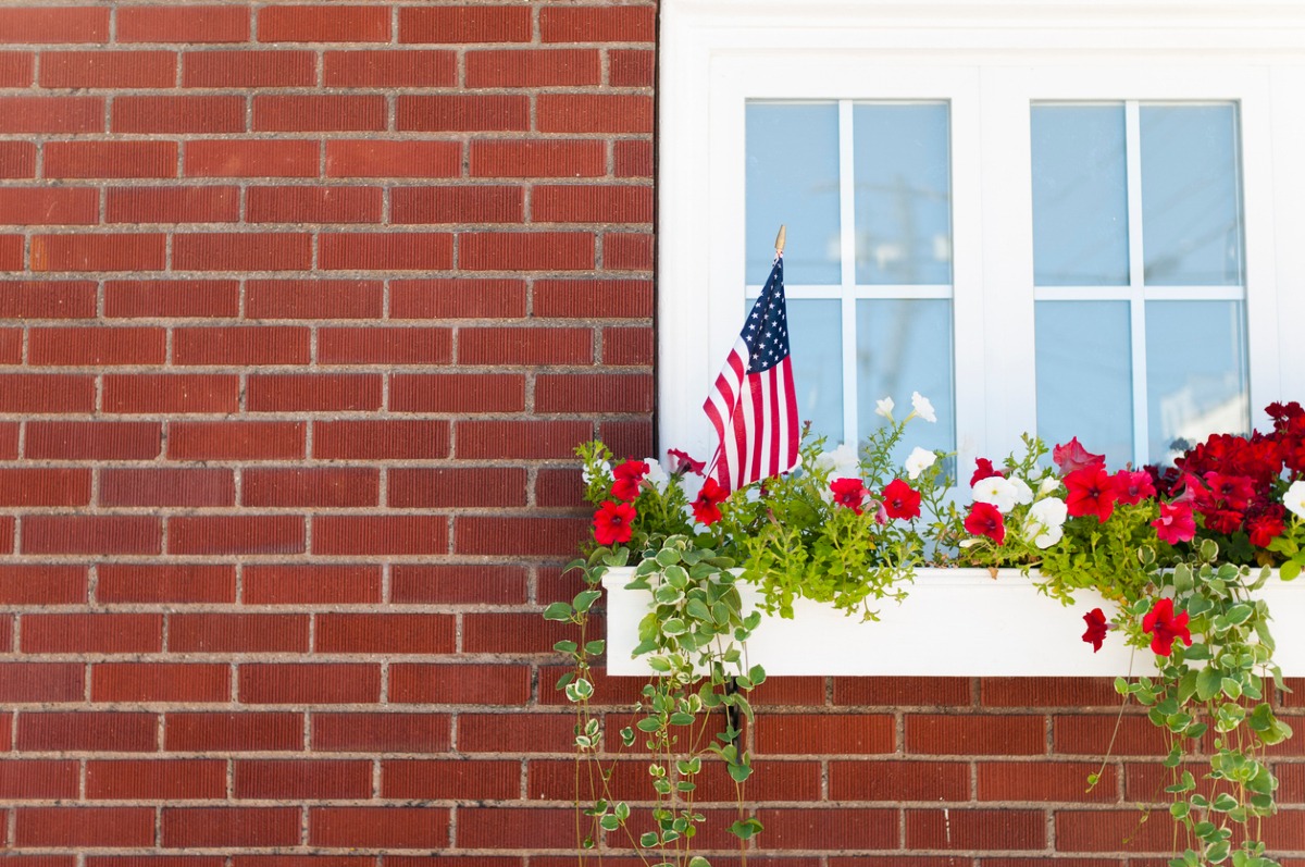 Brick home exterior with large sliding window and natural light, representing a calm and welcoming environment, often reflected by funeral homes in Riverside, CA to provide peaceful spaces for families during services and visitations.