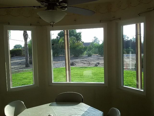 Bright dining area with large windows overlooking a green backyard in Riverside, CA.