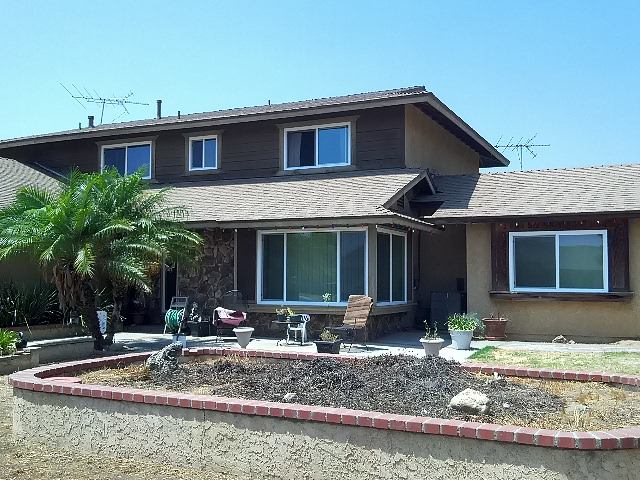 Two-story home with large replacement windows and landscaped yard in Riverside, CA.